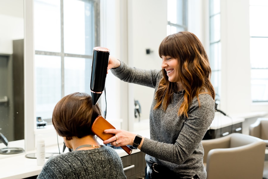 Profissional escovando o cabelo de uma cliente no salão